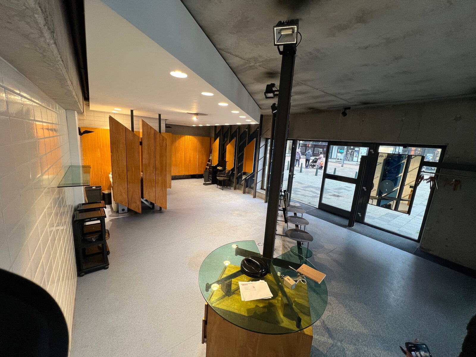 Originele kioskruimte vóór strip-out — verouderd interieur met houten panelen en vitrines