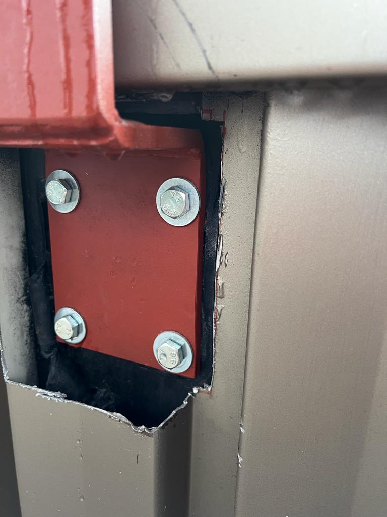 Detail boutverbinding — rode stalen plaat met vier 8.8 bouten door de borstwering
