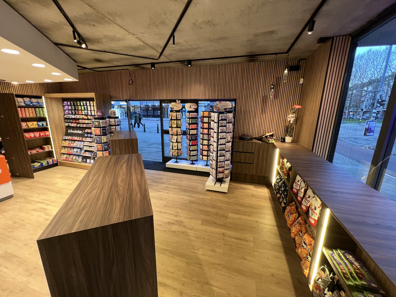 Gerealiseerde kiosk Rotterdam — winkelvloer met podium-displays, snackschappen en zicht op de gevel