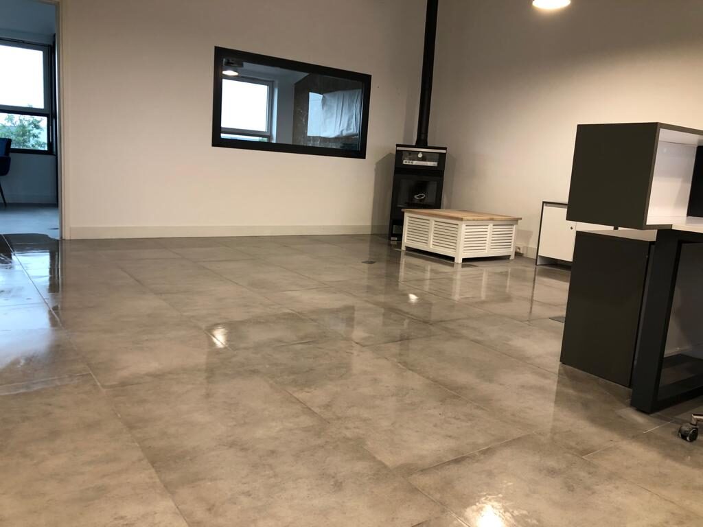Lounge zone met grootformaat tegelvloer, houtkachel en ingebouwde wandnis