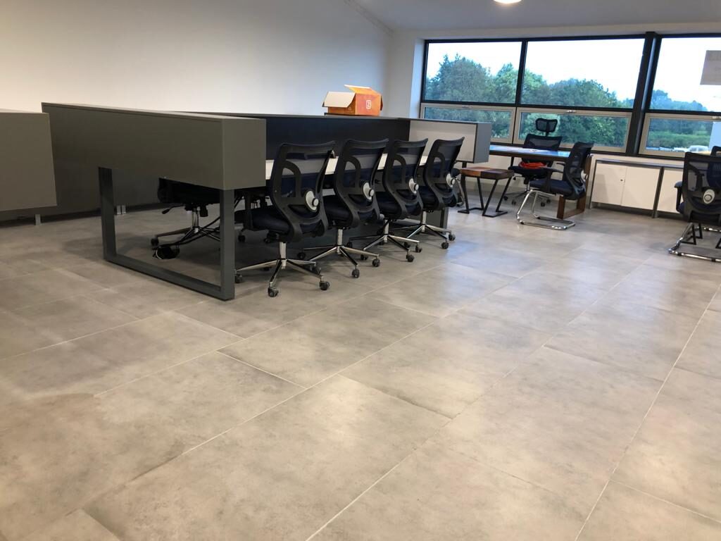 Open werkvloer met benchdesks, ergonomische bureaustoelen en panoramische raampartij