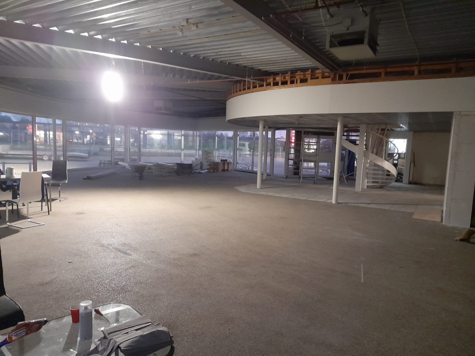Afgewerkte showroom met spiltrap, ronde mezzanine en grote pui