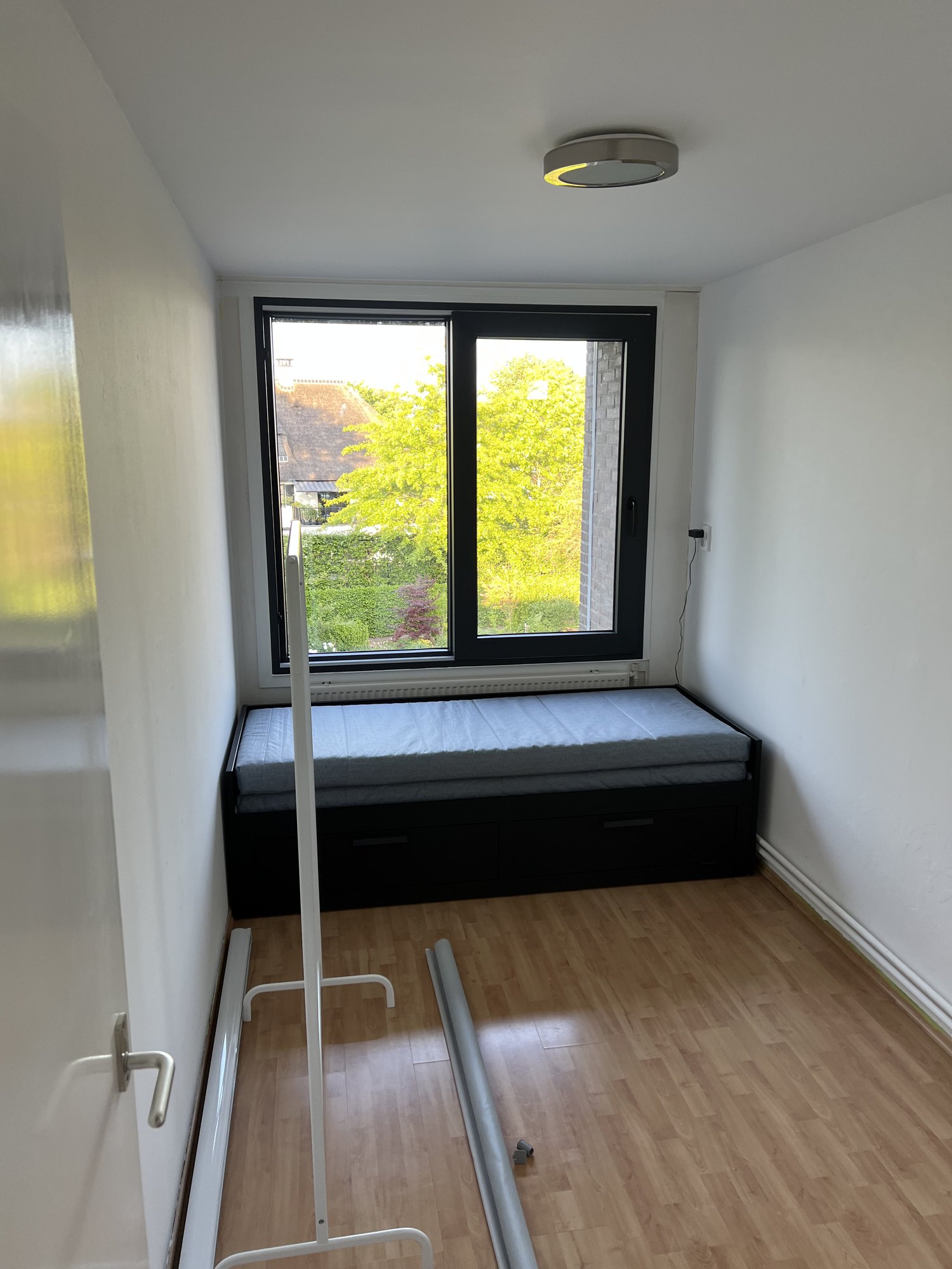Slaapkamer met geplaatst aluminium raamkozijn en plafondverlichting