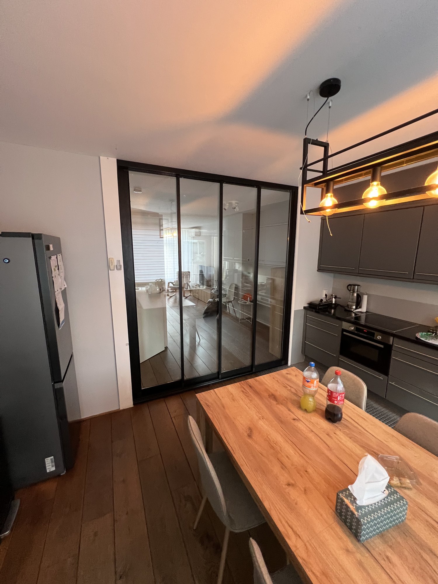 Brede opname van de keuken met aluminium 4-vaks schuifdeursysteem in zwart frame