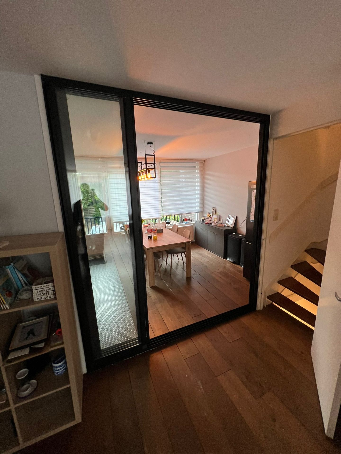 Eetkamerzijde met grote aluminium schuifdeurpui in zwart frame en heldere beglazing